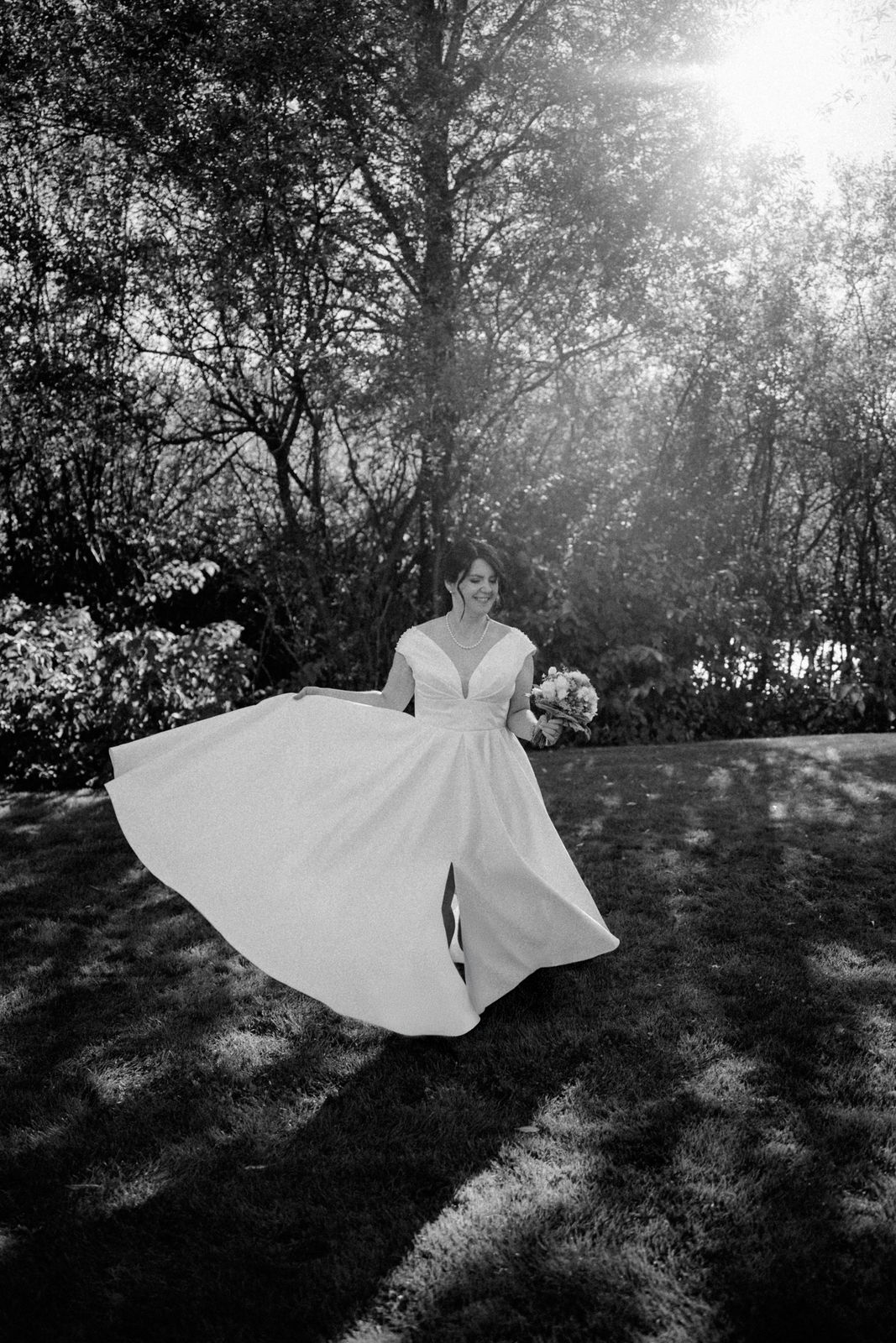 Bild in schwarz weiß von einer tanzenden Frau im Hochzeitskleid